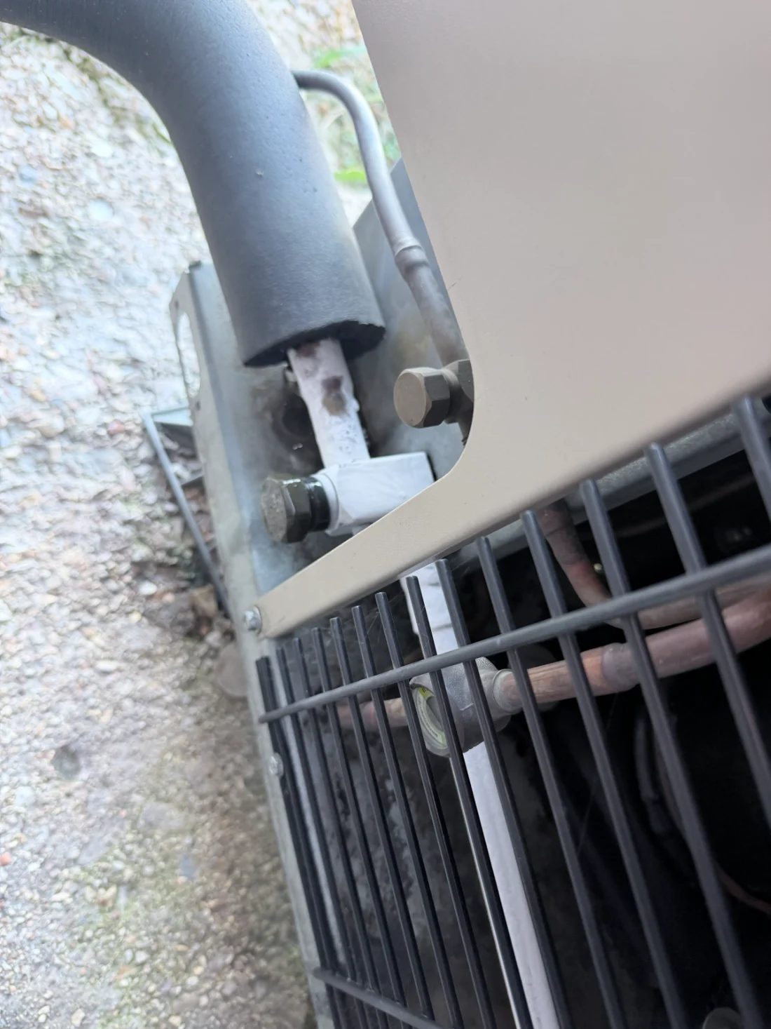 A close view of the refrigerant service connections and copper lines at a commercial condensing unit.
