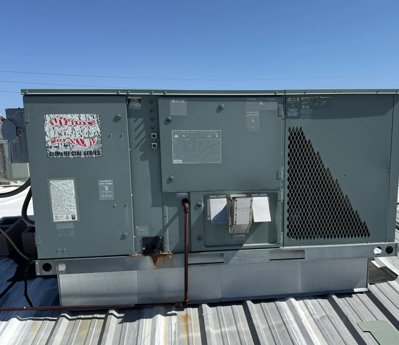 A packaged commercial rooftop HVAC unit installed on a metal building roof.